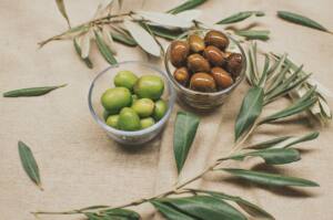 Dos envases con Aceitunas Rafael Salgado, verdes y negras, decoradas con ramas de olivo