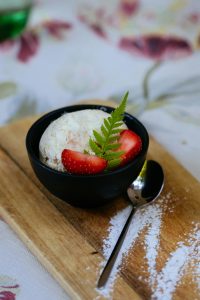 Un vaso de helado decorado con fresas